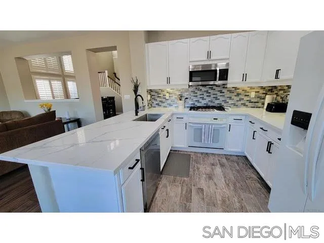 2476 Fallbrook Place Escondido, CA 92027 - Photo 12 of 33 a kitchen with granite countertop a sink stainless steel appliances and white cabinets