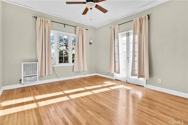 a view of a bedroom with wooden floor and a window