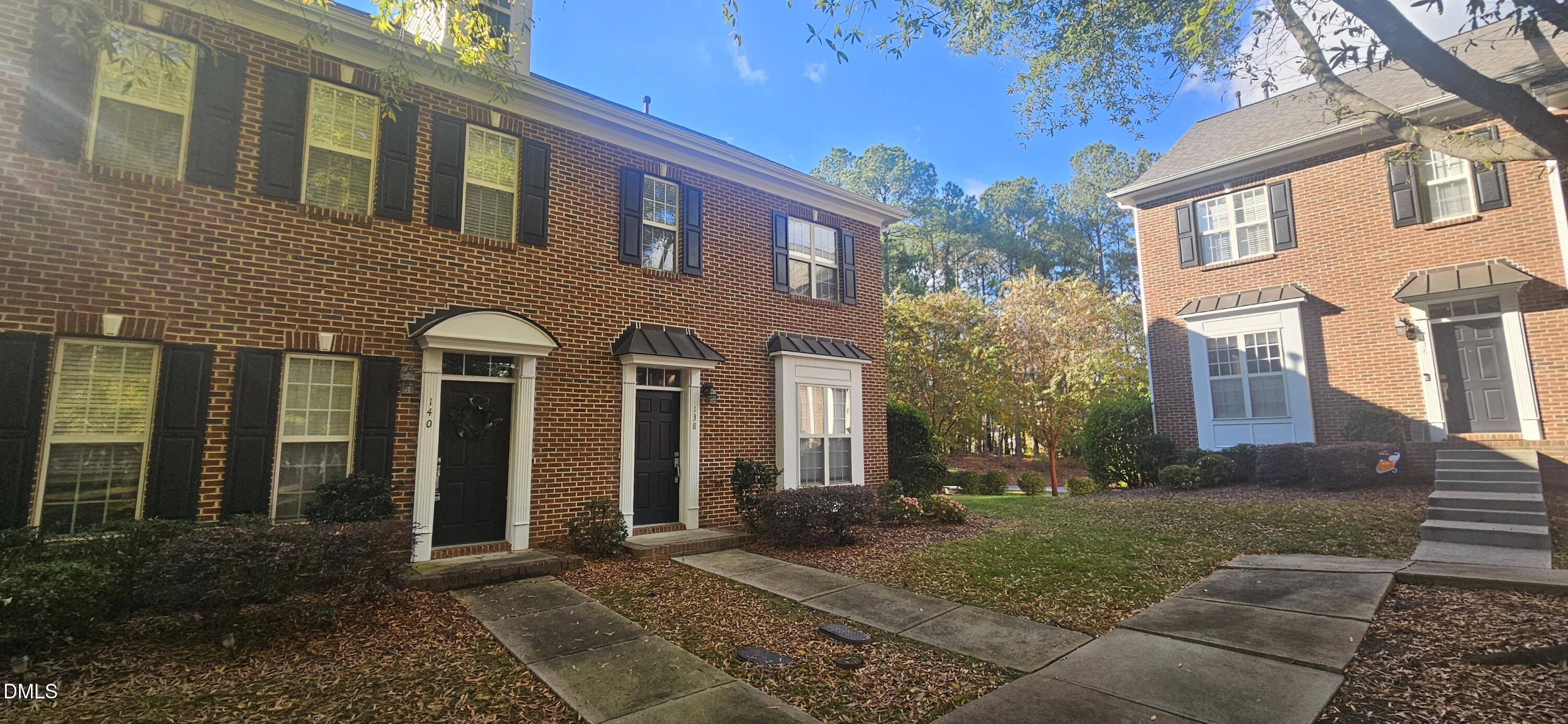 138 West Savannah Ridge Road Holly Springs, NC 27540 - Photo 2 of 22 a view of a brick house with many windows next to a yard
