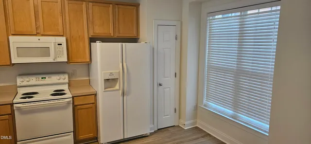a kitchen with white cabinets and white appliances