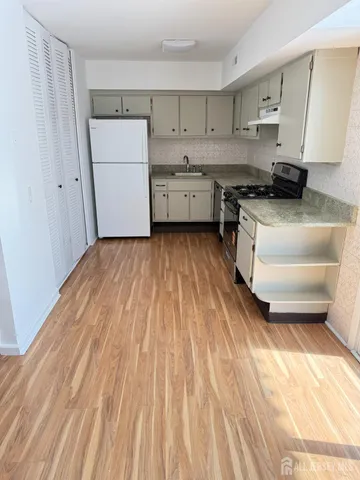 a kitchen with a sink a stove and cabinets