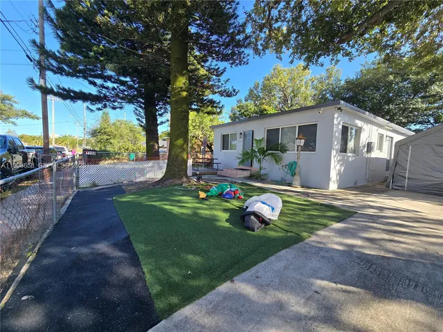 a view of a backyard with table and chairs plants and a barbeque