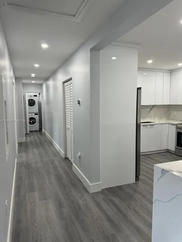 a view of a kitchen with a refrigerator and a stove top oven