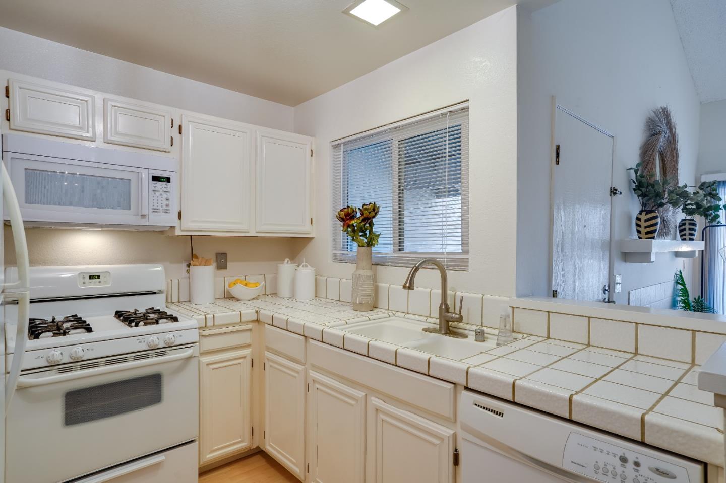 37050 Meadowbrook Common, Unit 302 Fremont, CA 94536 - Photo 11 of 21 a kitchen with kitchen island granite countertop white cabinets and white appliances