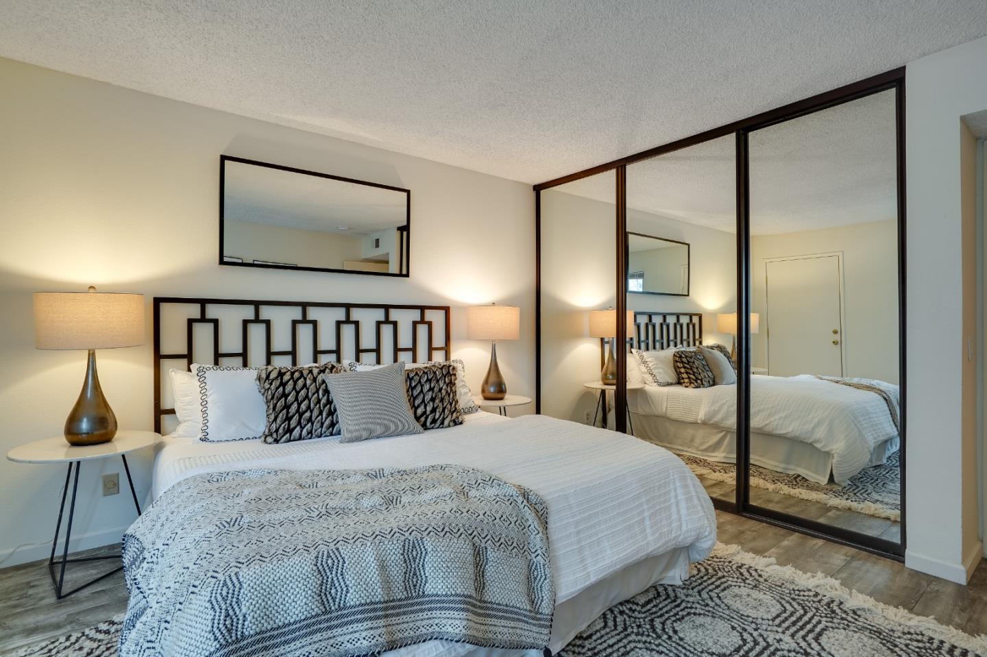 37050 Meadowbrook Common, Unit 302 Fremont, CA 94536 - Photo 12 of 21 a bedroom with a large bed and a mirror