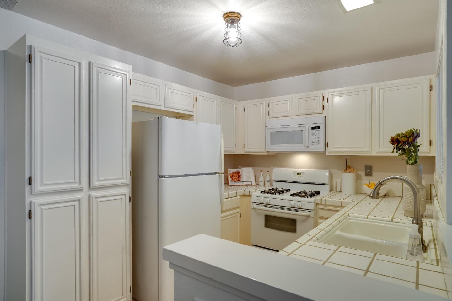 37050 Meadowbrook Common, Unit 302 Fremont, CA 94536 - Photo 10 of 21 a kitchen with a refrigerator a stove and a sink