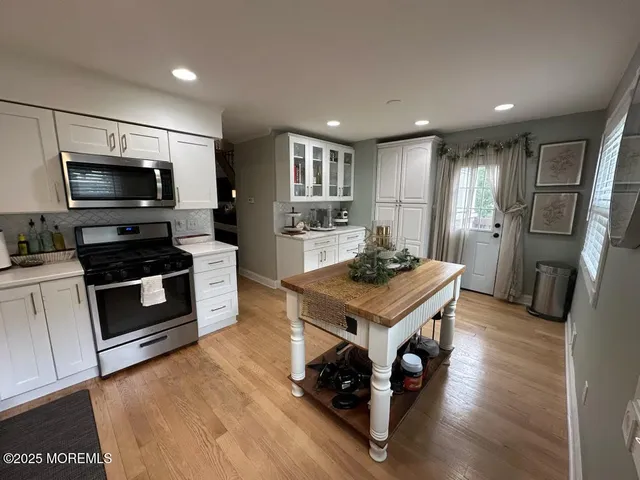 a kitchen with a refrigerator a stove top oven a sink dishwasher and wooden floor
