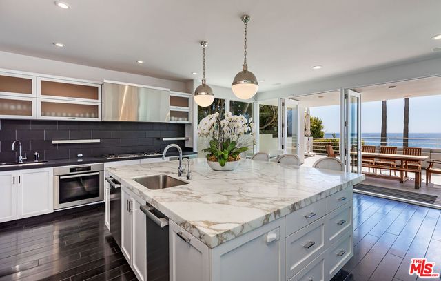 a kitchen with stainless steel appliances granite countertop stove top oven and cabinets