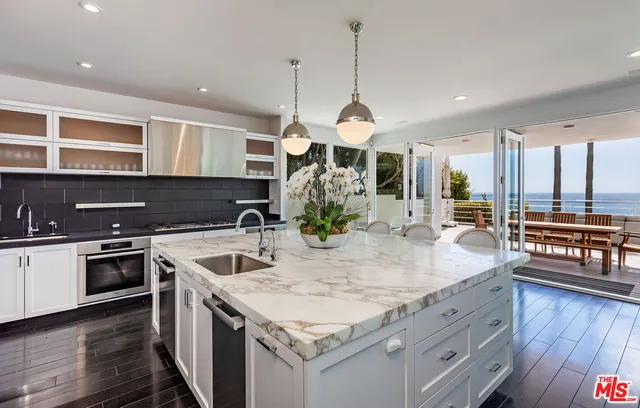 a kitchen with stainless steel appliances granite countertop stove top oven and cabinets