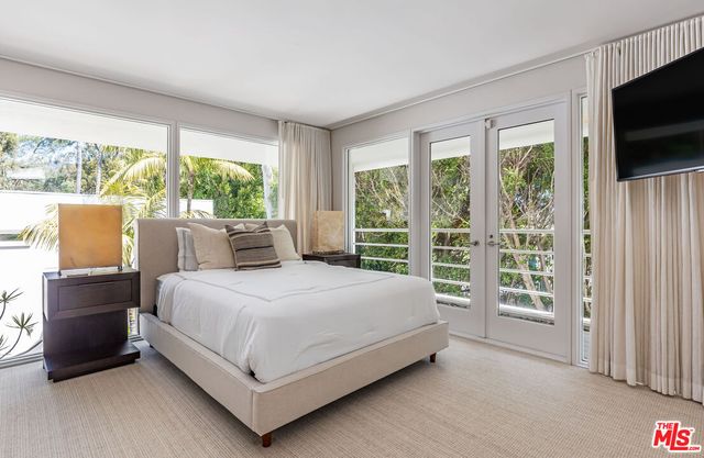 a bed sitting in a spacious bedroom next to a window