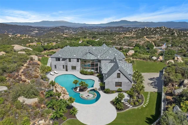 an aerial view of a house with a mountain