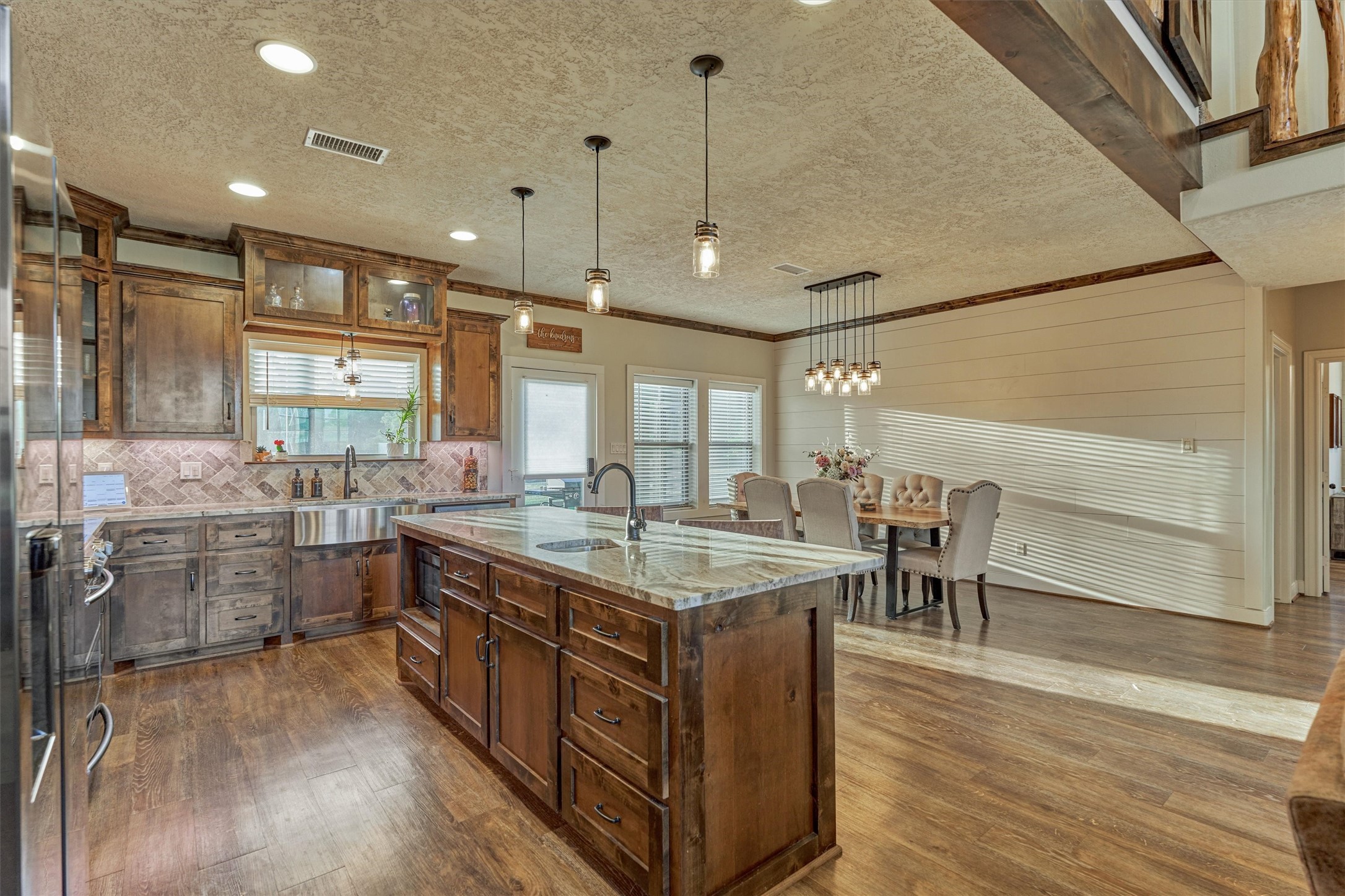 13125 Browder Traylor Road Willis, TX 77378 - Photo 20 of 50 a large kitchen with kitchen island a sink a stove a dining table and chairs with wooden floor