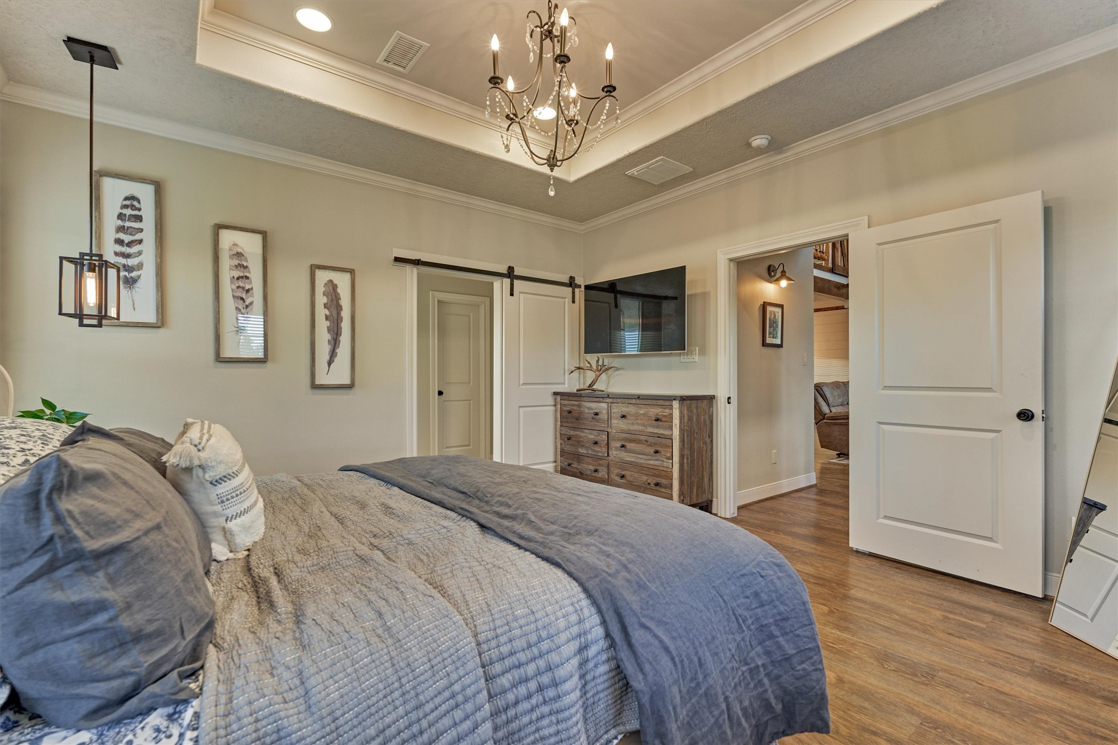13125 Browder Traylor Road Willis, TX 77378 - Photo 24 of 50 a spacious bedroom with a bed and a chandelier