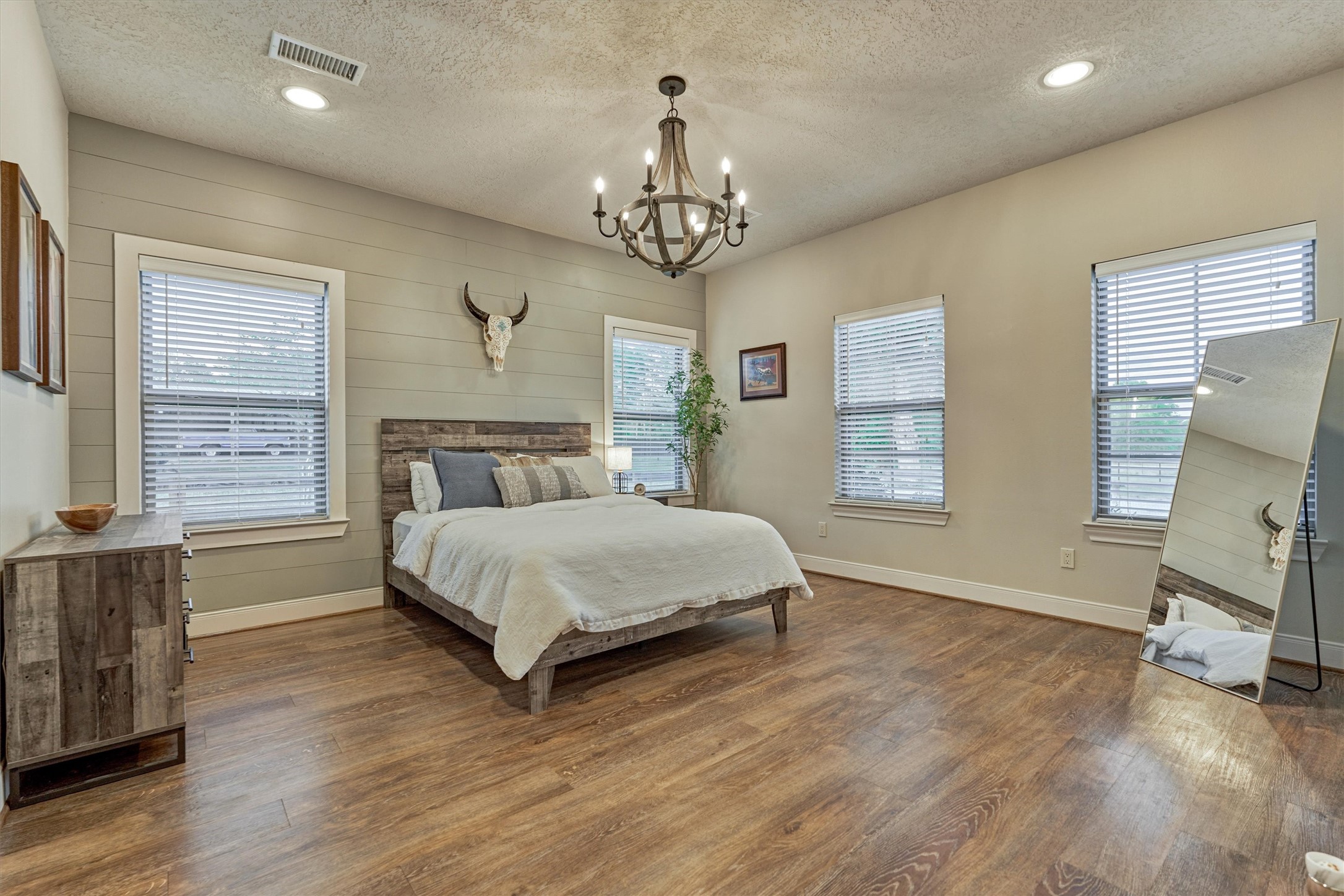 13125 Browder Traylor Road Willis, TX 77378 - Photo 29 of 50 a spacious bedroom with a bed and a chandelier