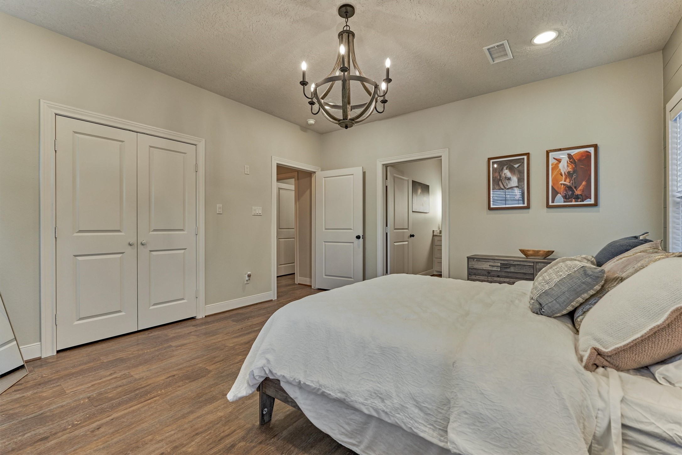 13125 Browder Traylor Road Willis, TX 77378 - Photo 30 of 50 a bedroom with a large bed and a chandelier