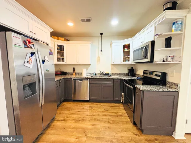 a kitchen with stainless steel appliances granite countertop a refrigerator and a stove