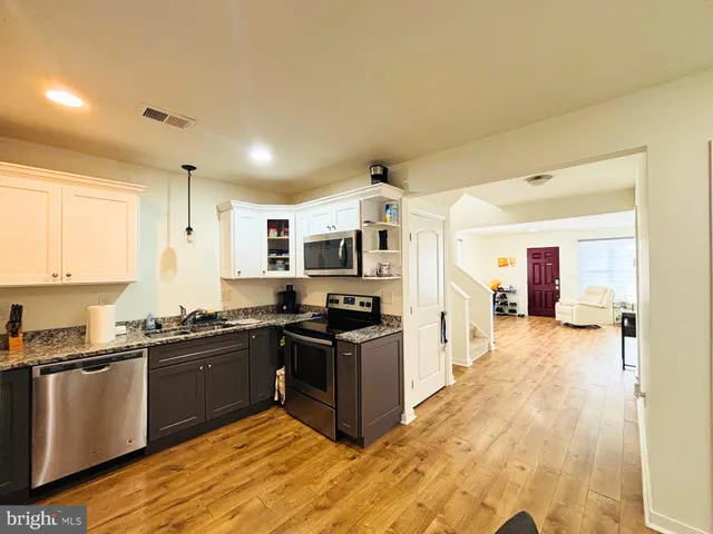 a kitchen with stainless steel appliances granite countertop a stove top oven a sink and dishwasher