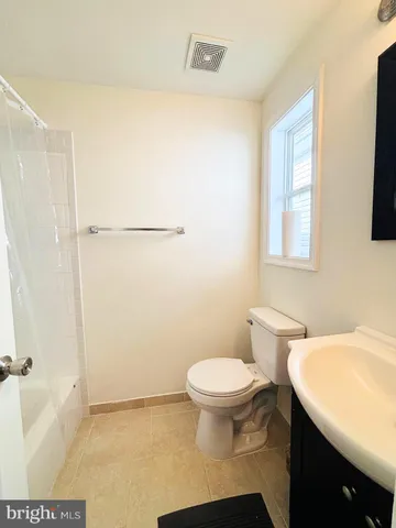 a bathroom with a sink a toilet a window and shower