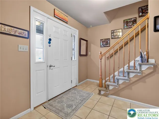 a view of staircase with lots of frames on wall and a large window