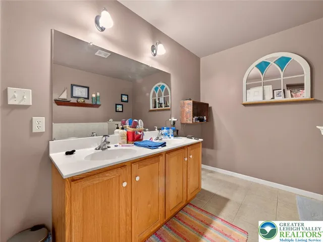 a bathroom with a sink a toilet and a large mirror