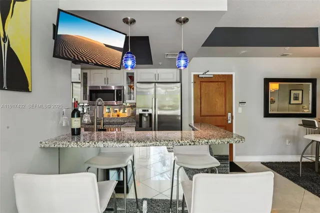 a kitchen with kitchen island granite countertop a sink cabinets and wooden floor