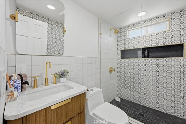 a bathroom with a granite countertop toilet sink and mirror