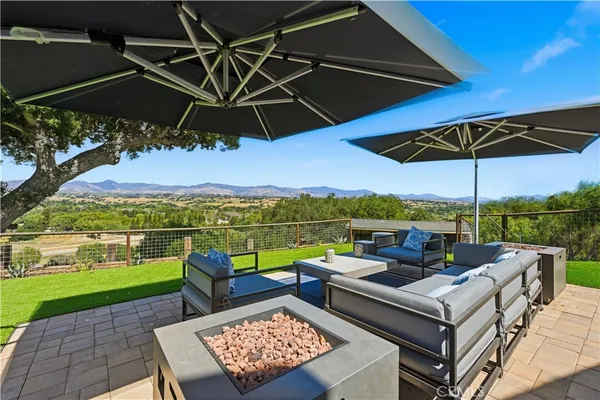 a view of a roof deck with couches under an umbrella