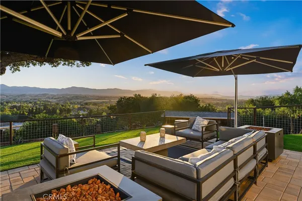 a view of a roof deck with couches under an umbrella