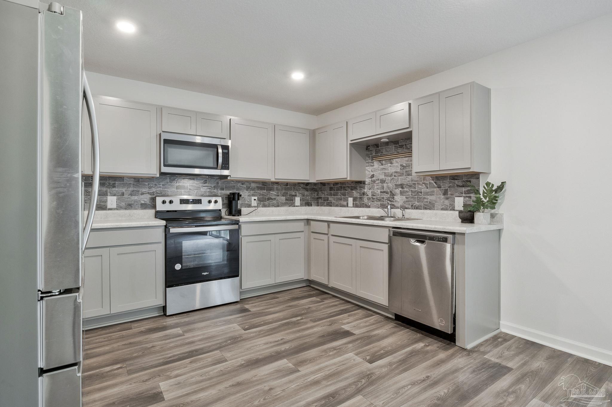1625 Addies Way Pensacola, FL 32534 - Photo 21 of 50 a kitchen with white cabinets stainless steel appliances and sink