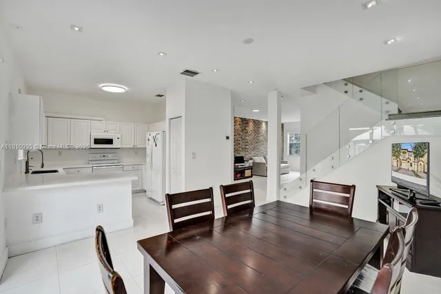 a living room with stainless steel appliances furniture and kitchen view