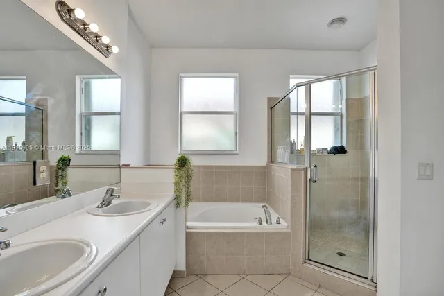 a bathroom with a granite countertop sink a mirror and a bathtub