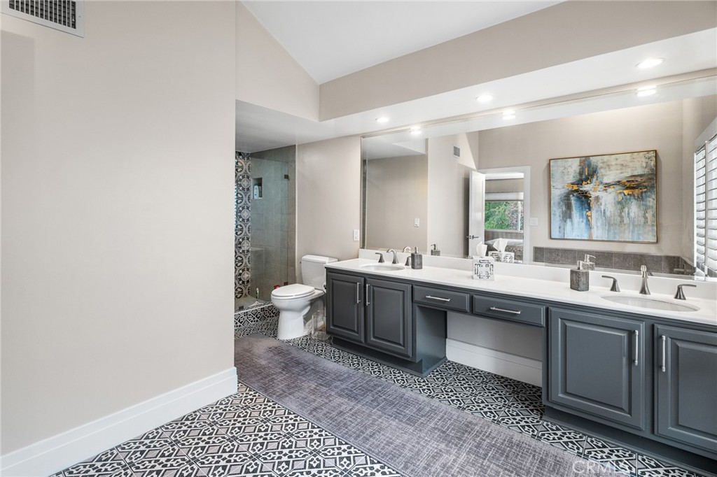 18927 Granada Circle Porter Ranch, CA 91326 - Photo 41 of 75 a spacious bathroom with a double vanity sink a toilet and a mirror