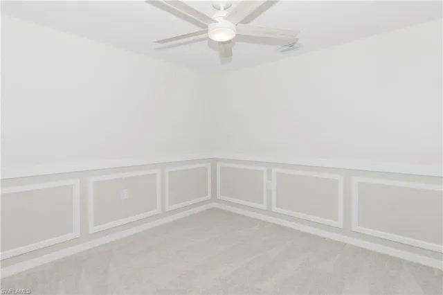 an empty room with closet and a ceiling fan