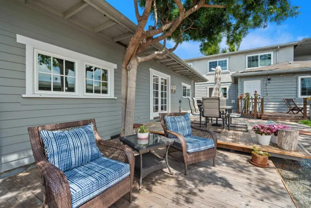deck with table and chairs and potted plants