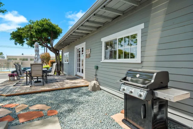 a view of a patio with table and chairs potted plants and large tree