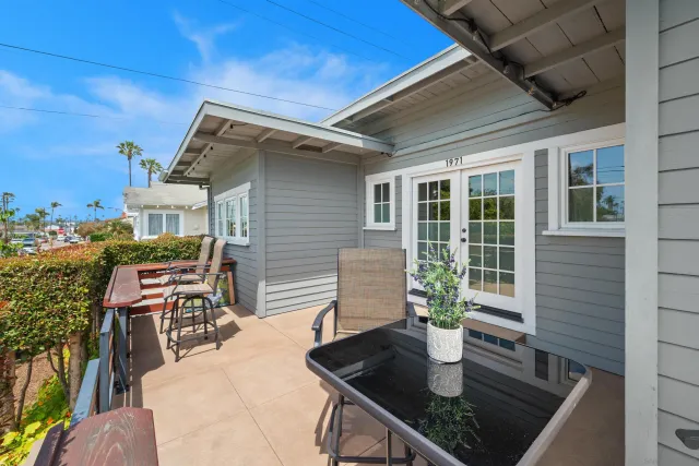 a patio with table and chairs and potted plants