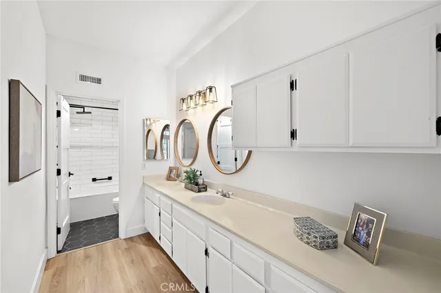 a bathroom with a double vanity sink mirror and shower
