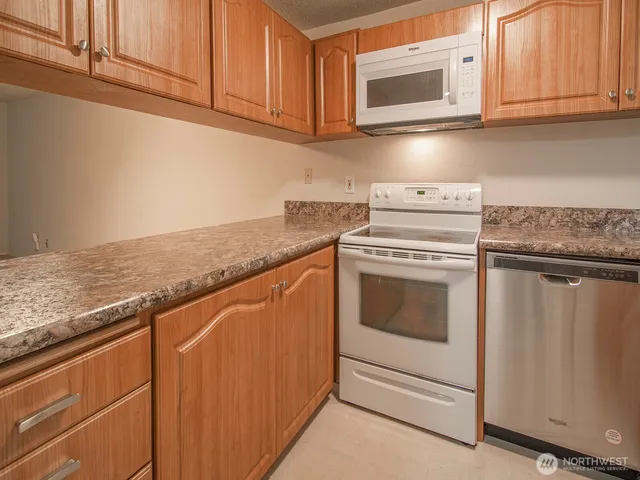 a view of kitchen with granite countertop cabinets a sink and dishwasher