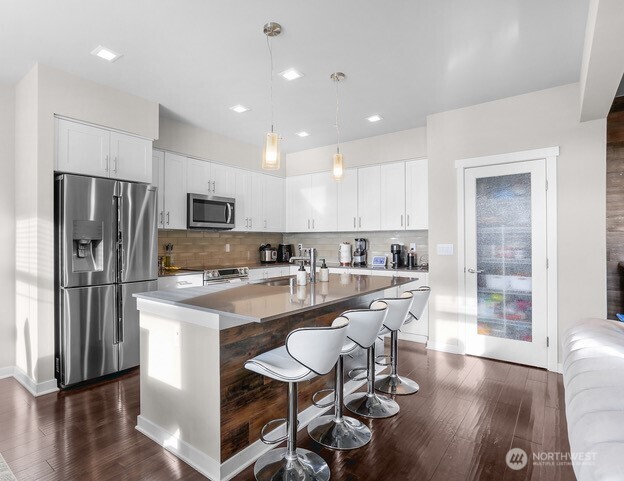 1325 Seattle Hill Road, Unit C2 Bothell, WA 98012 - Photo 8 of 26 a kitchen with stainless steel appliances granite countertop a refrigerator a stove top oven a sink dishwasher and white cabinets with wooden floor