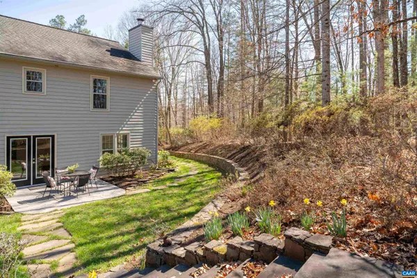 an empty room with wooden floor fireplace and windows