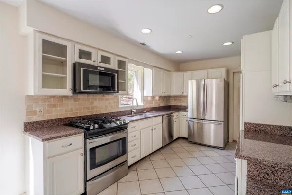 an empty room with wooden floor ceiling fan and windows