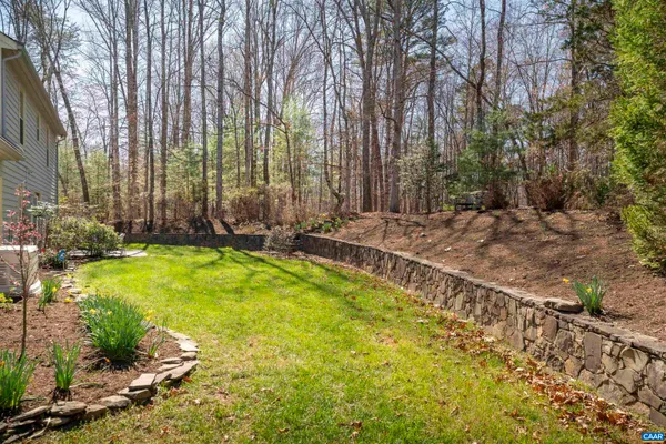 an empty room with windows a fireplace and wooden floor