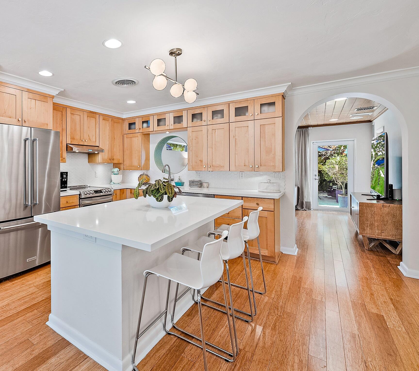 246 Gregory Road West Palm Beach, FL 33405 - Photo 7 of 20 a kitchen with stainless steel appliances granite countertop a refrigerator a sink dishwasher a stove and white countertops with wooden floor