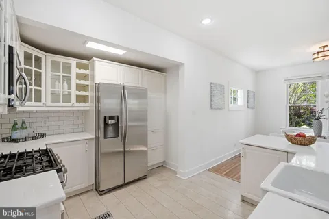 a kitchen with stainless steel appliances granite countertop a refrigerator and a stove