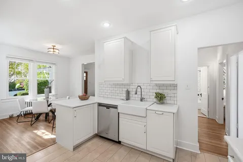 a kitchen with a sink white cabinets and white appliances