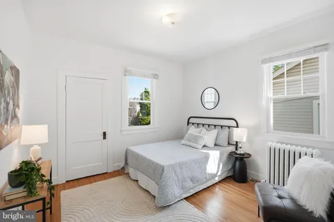 a bedroom with a bed mirror and a window
