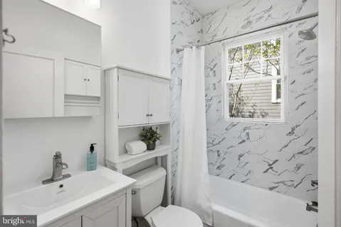 a bathroom with a sink toilet a mirror and shower