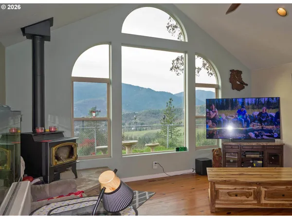 a living room with furniture a flat screen tv and a floor to ceiling window