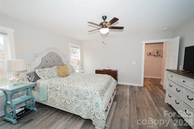 a bedroom with a bed and a flat tv screen on dresser