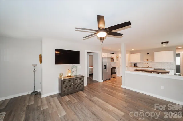 a living room with stainless steel appliances kitchen island granite countertop furniture and a flat screen tv